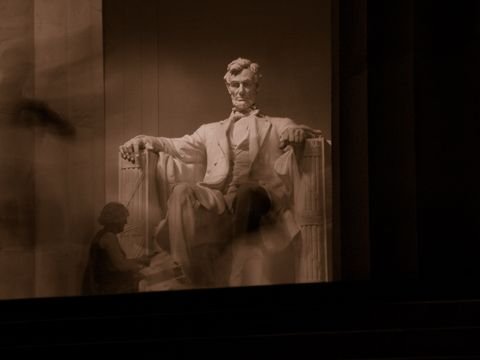 The Lincoln statue glowing above visitors blurred by a long exposure