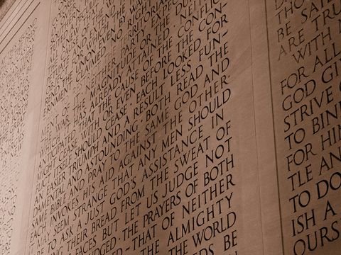The inscription wall at a raking angle, words carved in marble