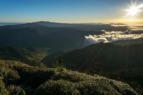 Late sun hanging over cloud-filled valleys